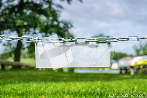 Image of Blank metal sign hanging on a chain