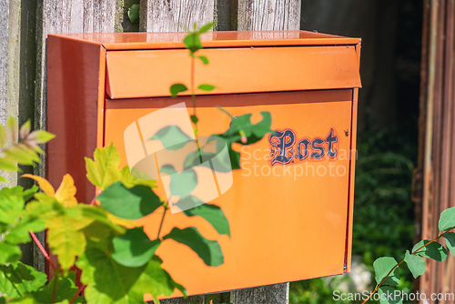 Image of Retro mail box on a wooden fence