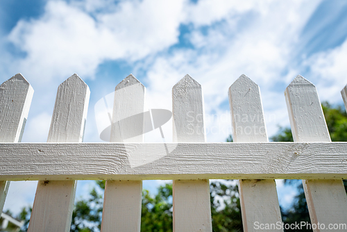 Image of White picket fence under a blue sky