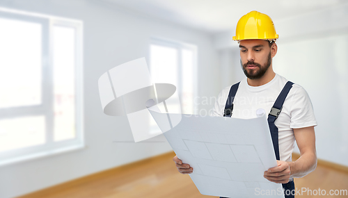 Image of male worker or builder in helmet with blueprint