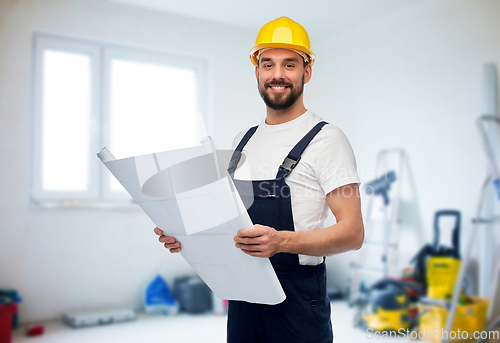 Image of male worker or builder in helmet with blueprint