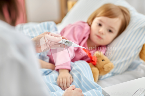 Image of doctor measuring sick girl's temperature