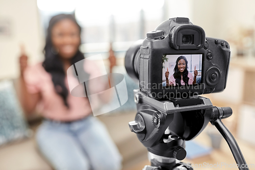 Image of female blogger with camera video blogging at home