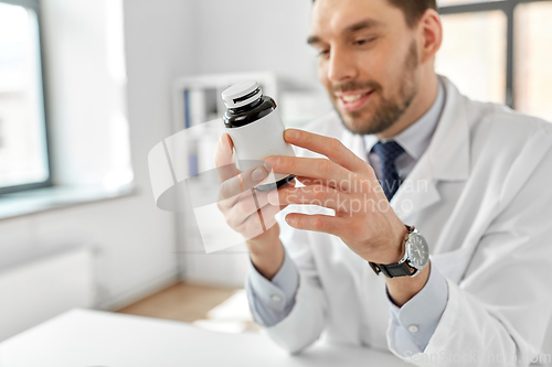 Image of smiling male doctor with medicine at hospital