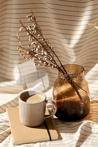 Image of cup of coffee, diary and dried flowers in vases