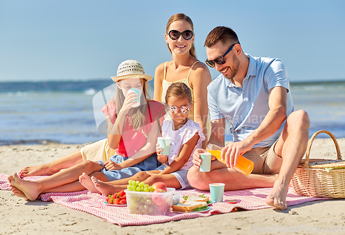 Image of happy family having picnic on summer beach