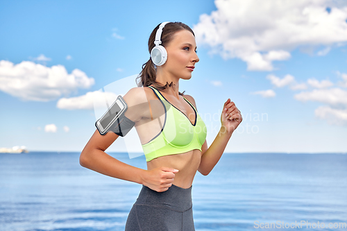 Image of woman with headphones and smartphone running