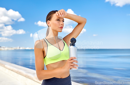 Image of woman drinking water from bottle after sports