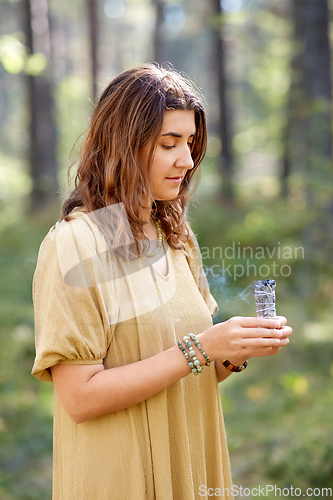 Image of woman or witch performing magic ritual in forest