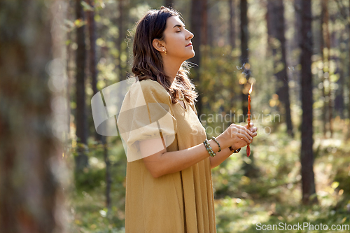 Image of woman or witch performing magic ritual in forest