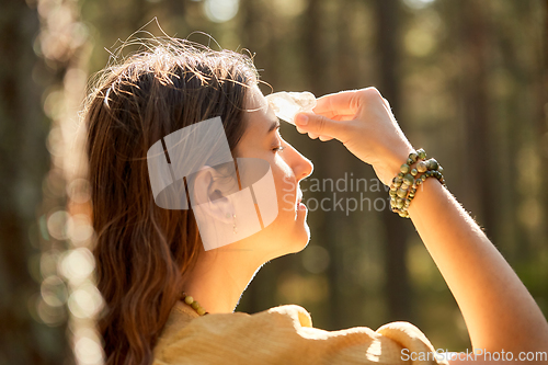 Image of woman or witch performing magic ritual in forest