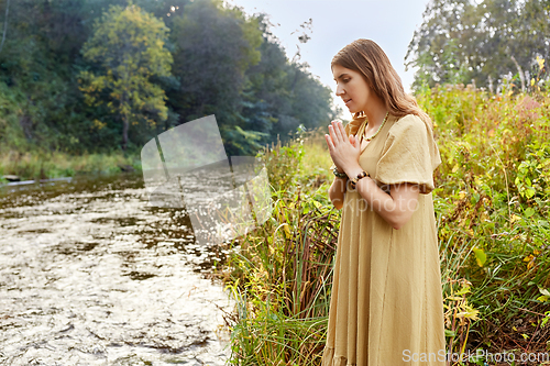 Image of woman or witch performing magic ritual on river