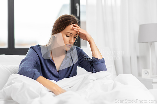 Image of sleepy woman sitting in bed at home