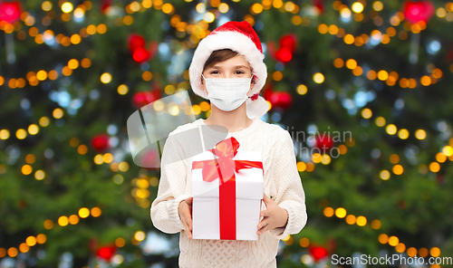 Image of boy in protective mask with christmas gift