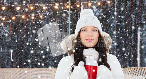 Image of woman with tea cup at ice skating rink in winter