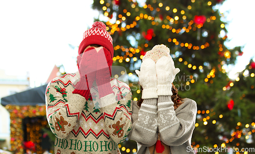 Image of couple in ugly sweaters and mittens on christmas