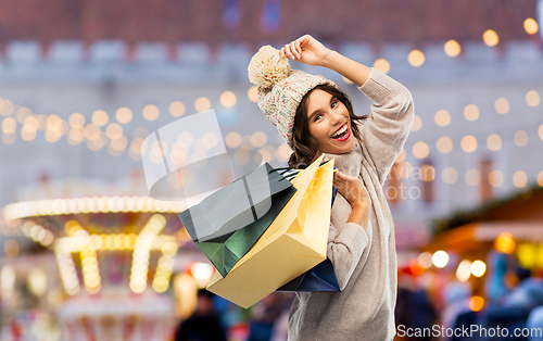 Image of young woman in winter hat with shopping bags