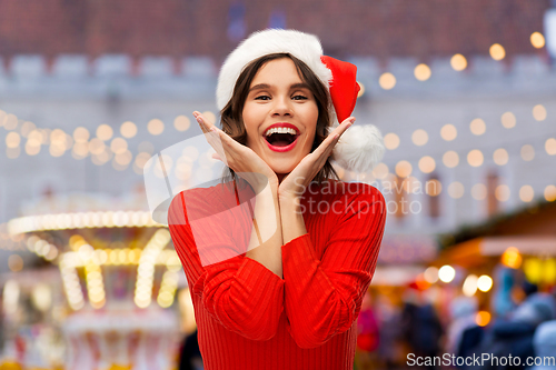 Image of happy young woman in santa hat on christmas