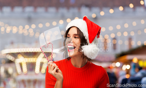 Image of happy young woman in santa hat on christmas