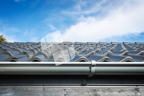 Image of Roof on a house with tiles and a gutter