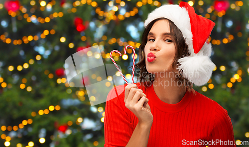 Image of happy young woman in santa hat on christmas