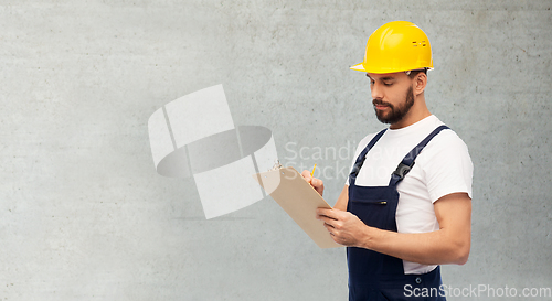 Image of male worker or builder in helmet with clipboard