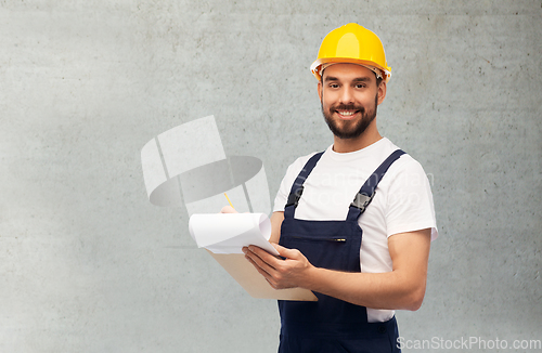 Image of male worker or builder in helmet with clipboard