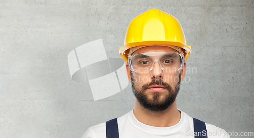 Image of male worker or builder in helmet and overall