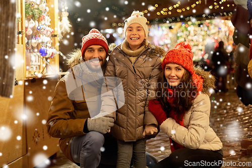 Image of happy family at christmas market in city