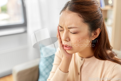 Image of asian woman suffering from toothache at home