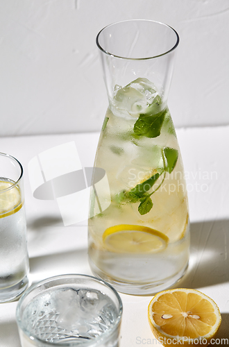 Image of glasses with lemon water and peppermint on table