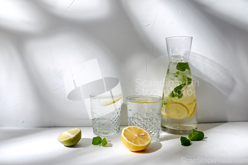 Image of glasses with lemon water and peppermint on table