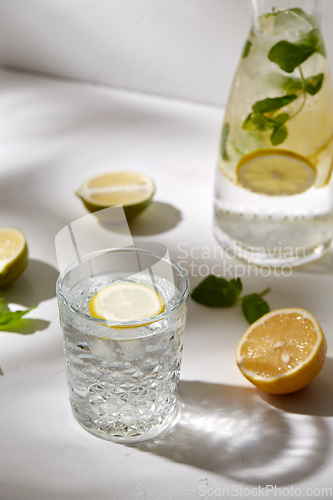 Image of glasses with lemon water and peppermint on table