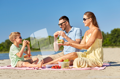 Image of happy family having picnic on summer beach