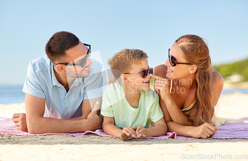 Image of happy family lying on summer beach