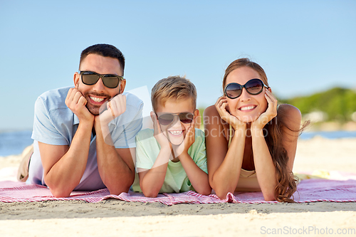 Image of happy family lying on summer beach