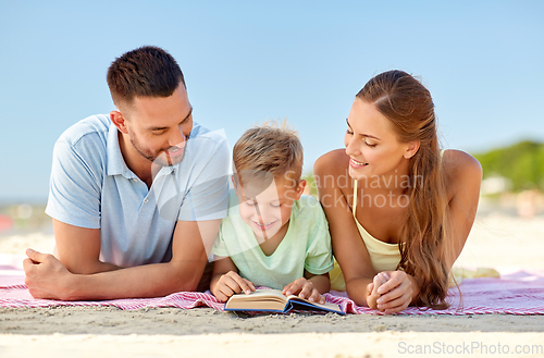 Image of happy family reading book on summer beach