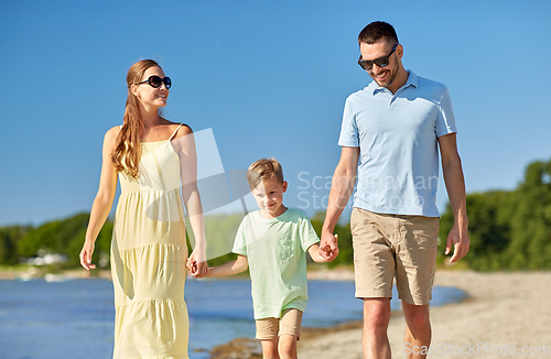 Image of happy family walking along summer beach