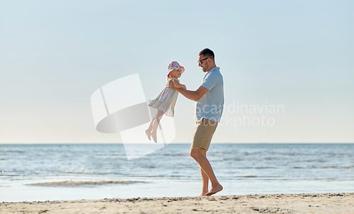 Image of happy father playing with little daughter on beach