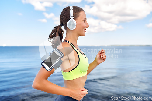 Image of running woman in headphones with smartphone