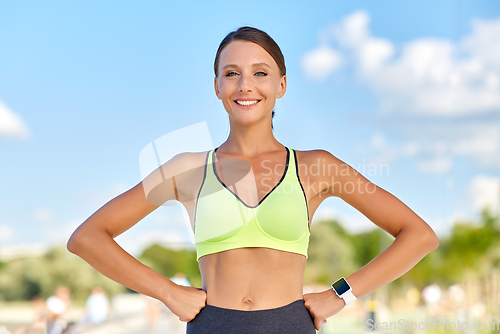 Image of portrait of smiling young sporty woman outdoors