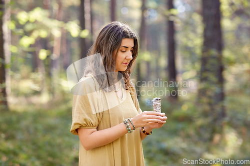 Image of woman or witch performing magic ritual in forest