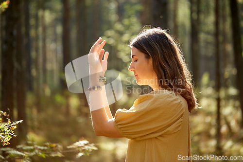 Image of woman or witch performing magic ritual in forest