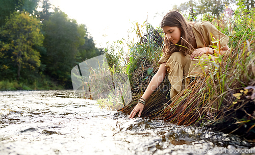 Image of woman or witch performing magic ritual on river