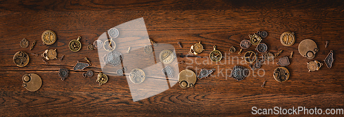 Image of Mechanical cogwheel elements on a dark wooden surface