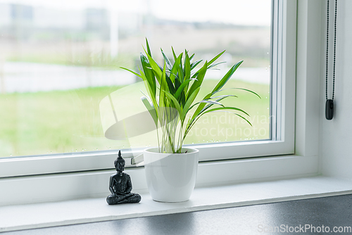 Image of Green plant with a Buddha figure