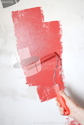 Image of painting a wall with a roll