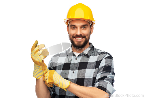 Image of happy male worker or builder in helmet and gloves