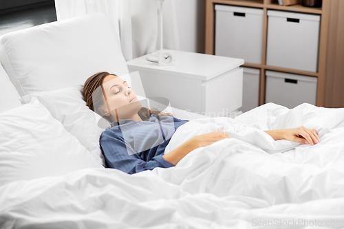 Image of young woman sleeping in bed at home