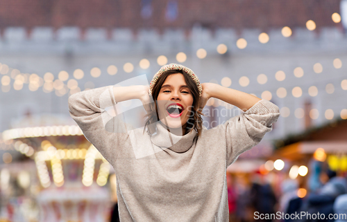 Image of happy woman in hat and sweater at christmas market